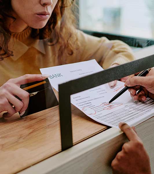 Photo of woman and bank teller going over bank statement