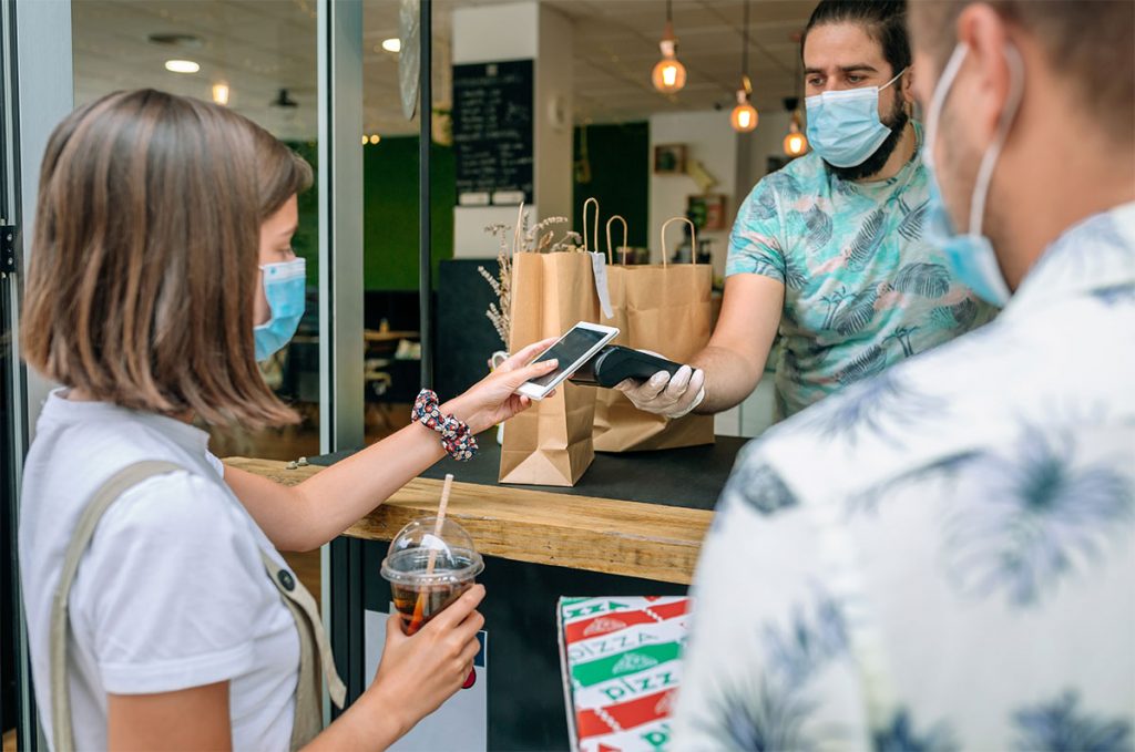 Corporate-Research-Blog Woman paying with mobile a take away order