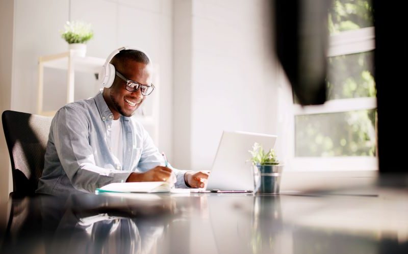man wearing headphones working on a laptop