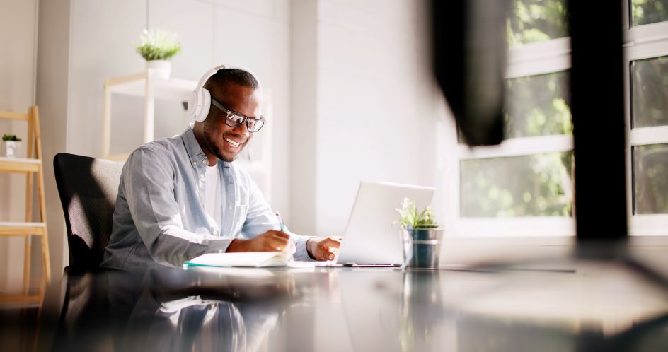 man wearing headphones working on a laptop
