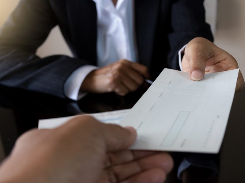 one person handing a check to another