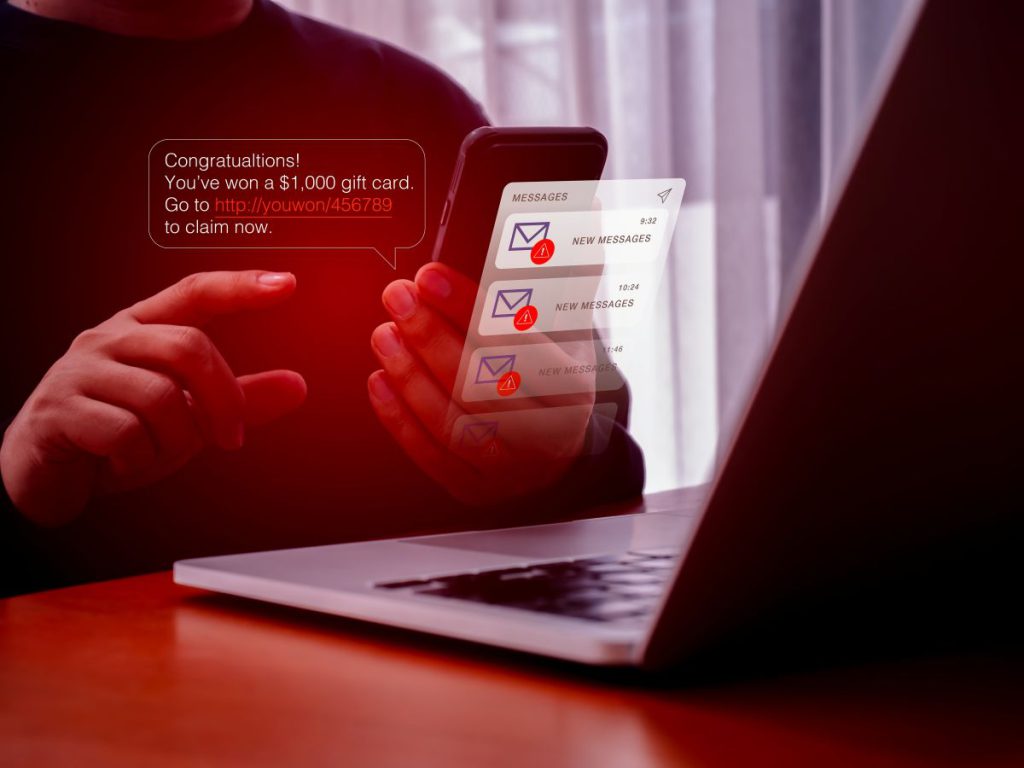 A person at a computer receiving fraudulent emails